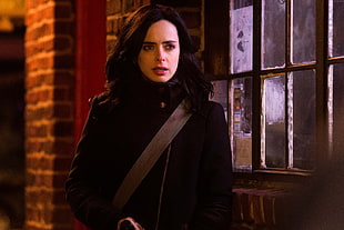 woman in black jacket beside window