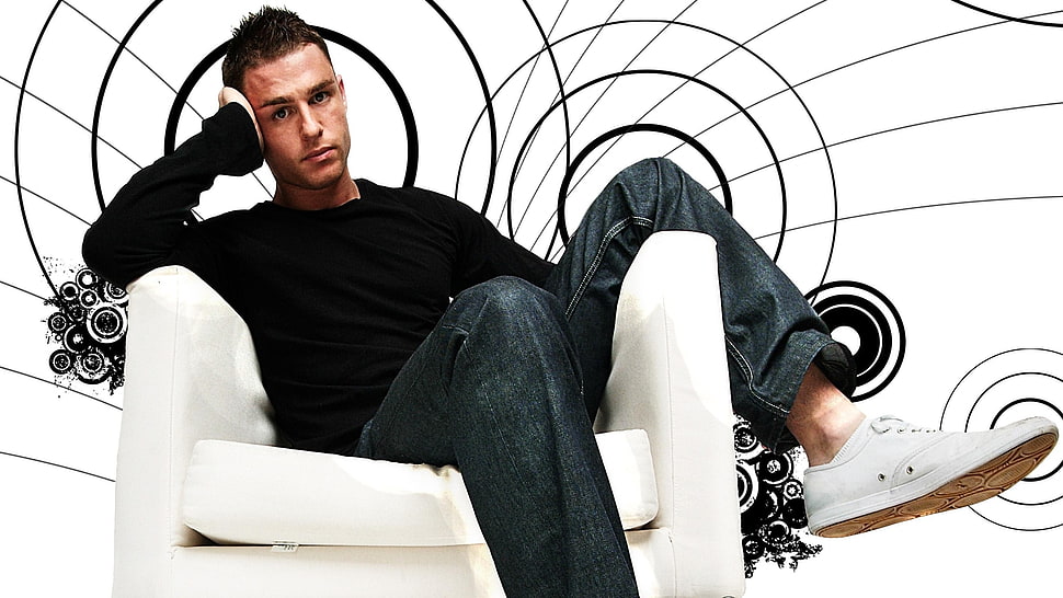man in black sweatshirt and jeans sitting on white chair HD wallpaper
