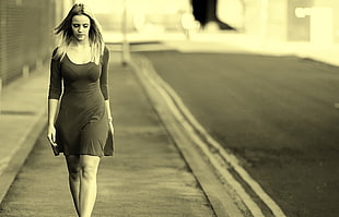 woman in quarter-sleeved dress walking on street