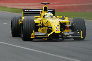 yellow F1 car on concrete road during daytime