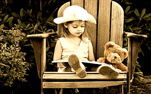 photo of child wearing white hat sitting on armchair