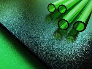 four green tubes on black wooden board, glass, pipes, pattern, reflection
