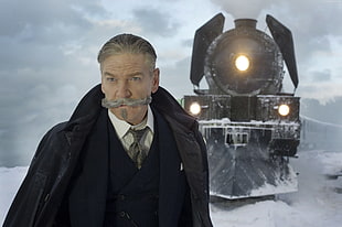 man wearing black suit behind black train