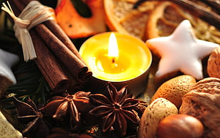 tealight candle in middle of star anise, nuts, cookies and cinnamon sticks HD wallpaper