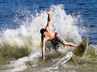 photo of man surfing on big waves