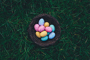 colored eggs on brown wicker basket