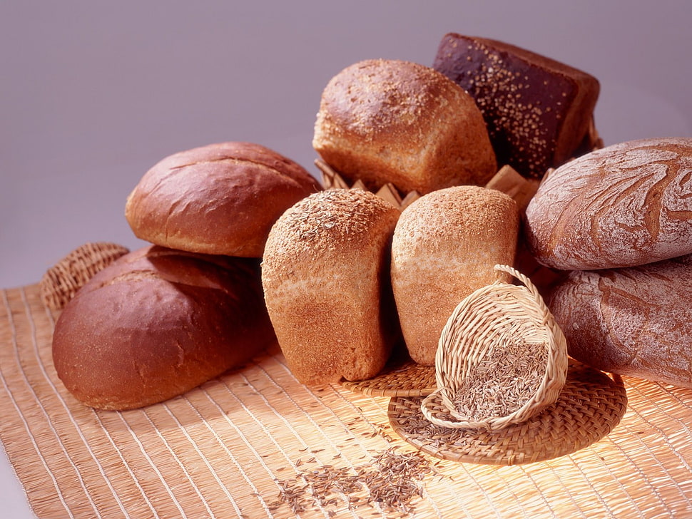 bunch of breads beside white basket on mat HD wallpaper
