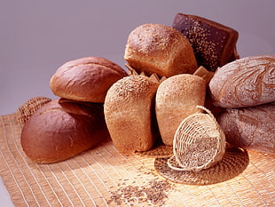 bunch of breads beside white basket on mat