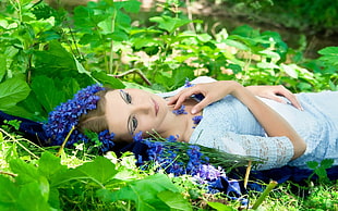 woman in white scoop-neck dress lying on green leaves plant