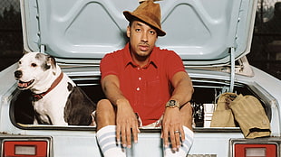 man wearing red polo shirt and brown fedora hat