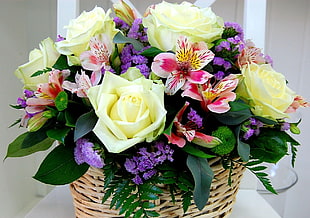 purple, yellow and pink flower bouquet on brown wicker basket