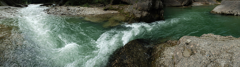 flowing water surrounded with stones HD wallpaper