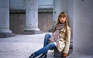 girl leaning on white concrete pillar during daytime
