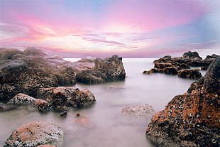 landscape photography of rocks on body of water HD wallpaper