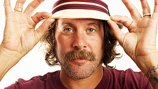 bearded man wearing white and red striped bucket hat