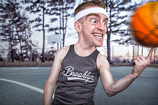 person wearing black Brooklyn tank top with ball spinning on index finger \