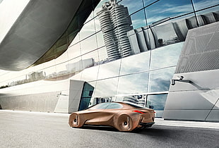gold concept sports coupe beside glass building