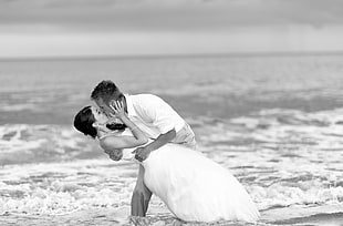 man kissing woman beside body of water