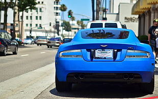blue sports coupe parked ahead beside buildings HD wallpaper