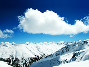 aerial photography of snow covered mountains under white and blue sunny cloudy sky