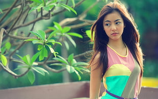 selective focus photography of girl wearing pink, yellow, and green tank top