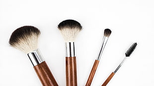 four brown handled makeup brushes