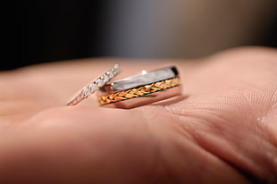 silver, gold, and diamond engagement ring set on human palm
