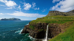 photograph of waterfalls rushing onto sea, landscape, waterfall, cliff