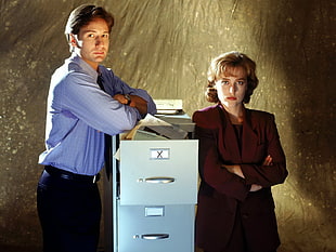 man and woman standing in between of gray filing cabinet
