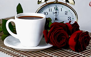 white ceramic mug beside roses