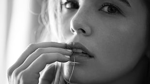 grayscale photography of woman put her hand on lip