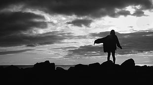 sillhoutte on woman in jacket standing on stones