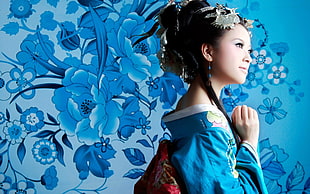 woman wearing blue kimono and flower head ornaments