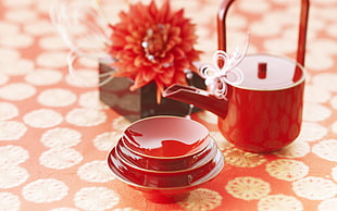 red ceramic tea set with red cluster flower