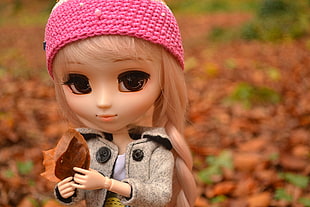 brown plastic doll holding dried leaves, tokyo HD wallpaper