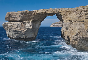 lanscape photography of arch formed gray rock over body of water, malta, gozo