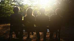 group of four people sitting on bench