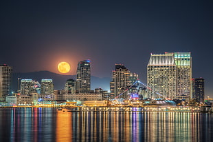 panoramic photo of city during nighttime and full moon HD wallpaper