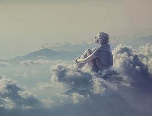 photo of man sitting on clouds