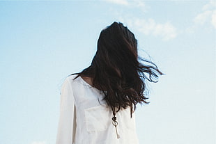photo of woman wearing white shirt with hair covering her face