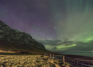grey mountain underneath purple and green sky during nighttime, iceland