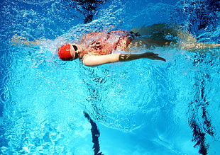 swimmer swimming in spots pool during daytime