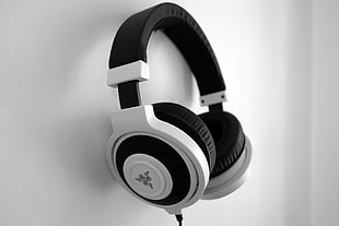 white and black Razer corded headphones hung on white wall