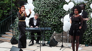 two woman in black dresses winging with electric keyboard accompaniment