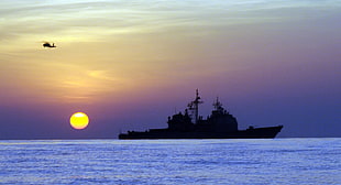 silhouette of boat and helicopter during sunset