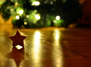 selective photography of brown wooden star decor on brown laminated floor tile
