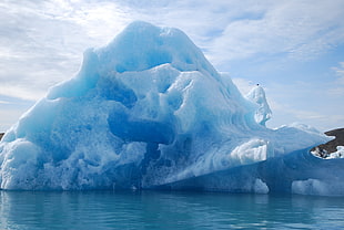 iceberg under white cloud and blue sky