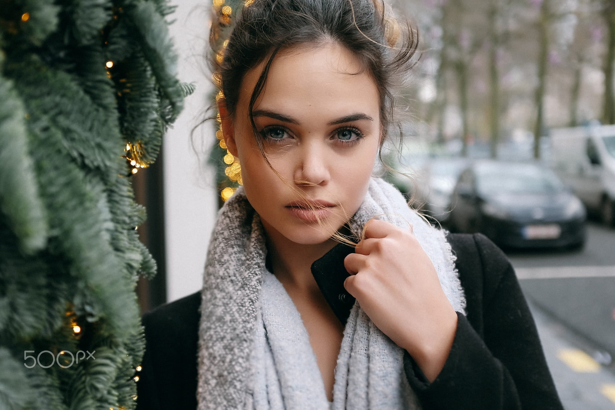 woman wearing gray scarf and black coat beside green pines