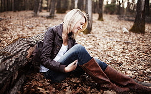 woman sitting dried leaves leaning on wood log