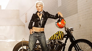 woman in black leather jacket leaning on black chopper motorcycle